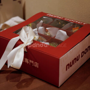 red and pale yellow paperboard donut box with clear window lid and divider grid for bakery gift packaging