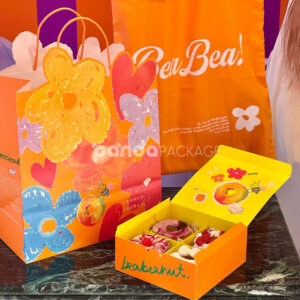 colorful paperboard donut gift box and bag with hand-painted illustration and yellow interior for bakery and dessert packaging